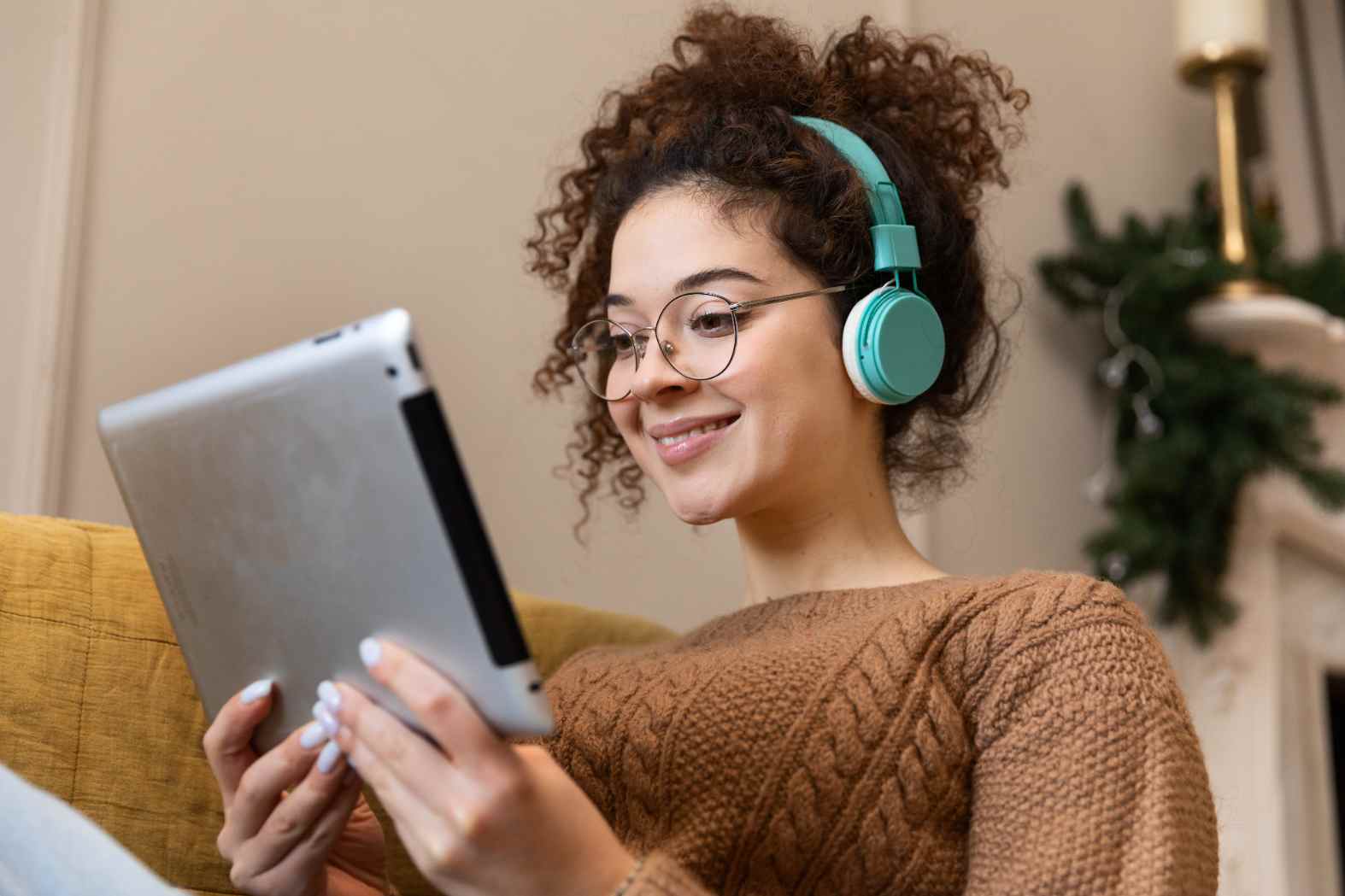 Estudante com tablet e fones de ouvido, usando conteúdos digitais para aprender e demonstrar letramento digital: navegar, compreender e acessar informações de forma crítica e consciente.